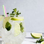 Close-up of a refreshing mojito cocktail with lime and mint, perfect for summer.